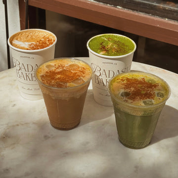selection of four fall drinks including a hot cinnamon roll latte, iced spice pumpkin shaken espresso, hot chai matcha latte, and an iced pumpkin matcha.