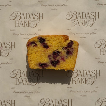 slice of blueberry cornbread loaf on badash bakery sheet